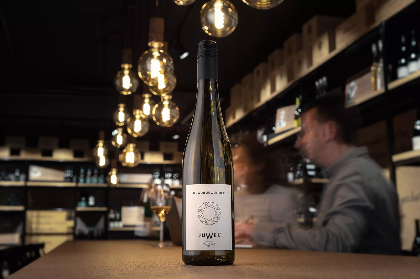 Flasche Juwel Grauburgunder auf dem Tisch in der dunklen Vinothek Hauser