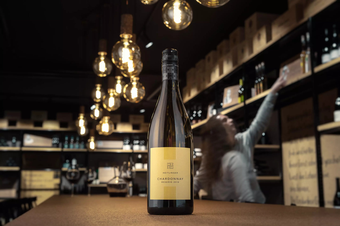 Flasche Chardonnay Reserve vom Weingut Heitlinger in der Vinothek Hauser auf dem Tisch.