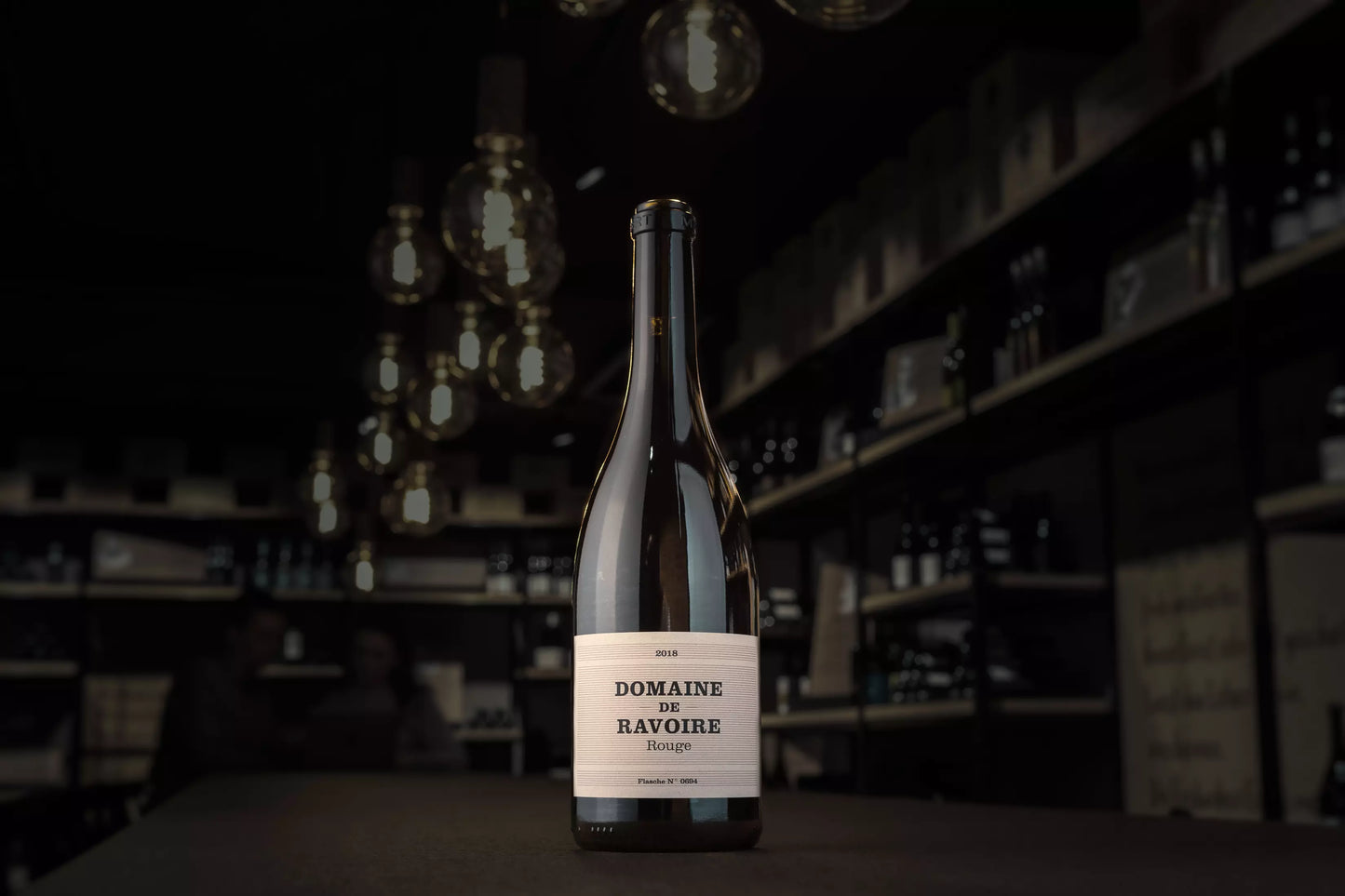 Flasche Domaine de Ravoire rouge auf dem Tisch in der dunklen Vinothek Hauser.