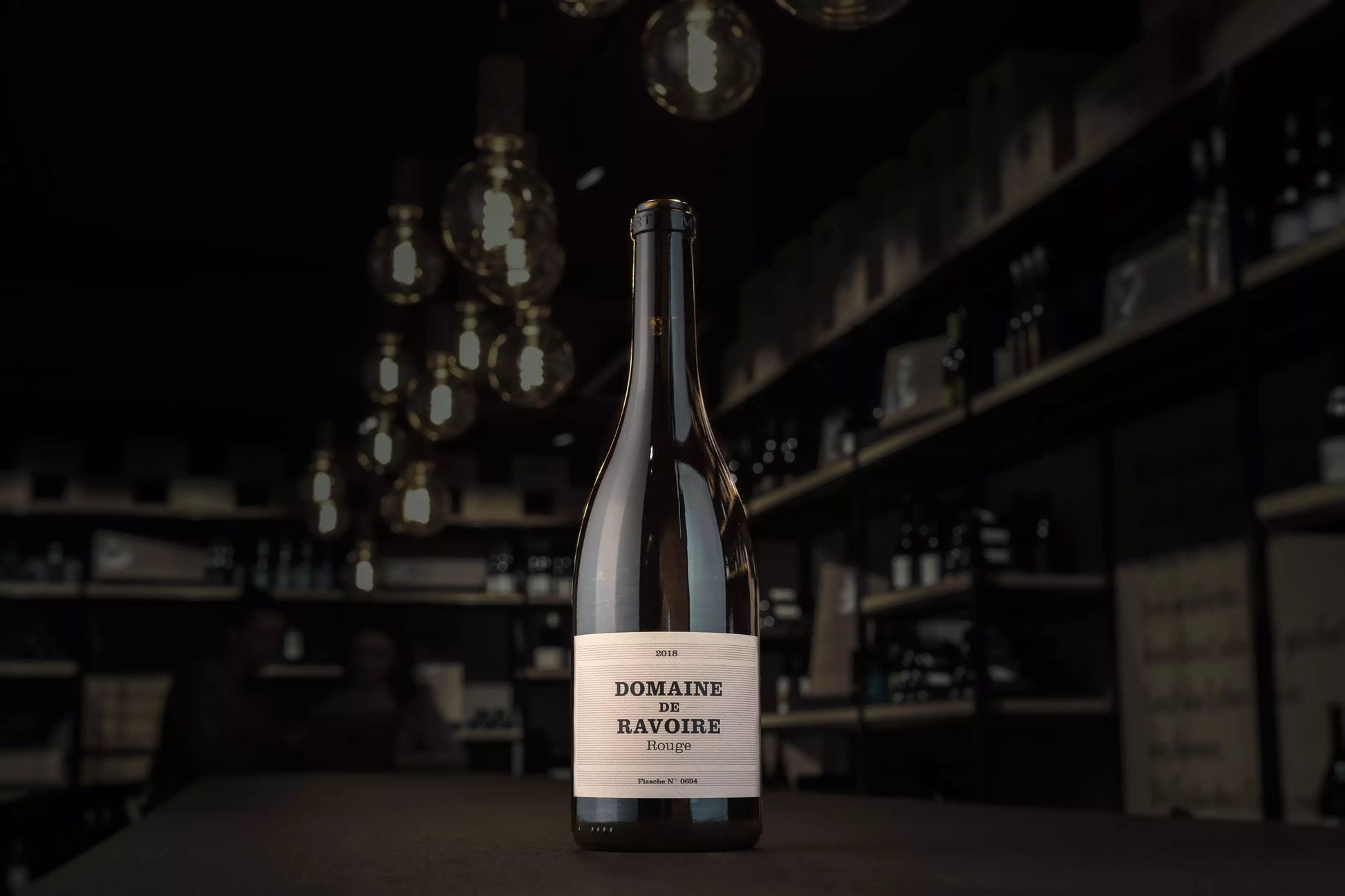 Flasche Domaine de Ravoire rouge auf dem Tisch in der dunklen Vinothek Hauser.