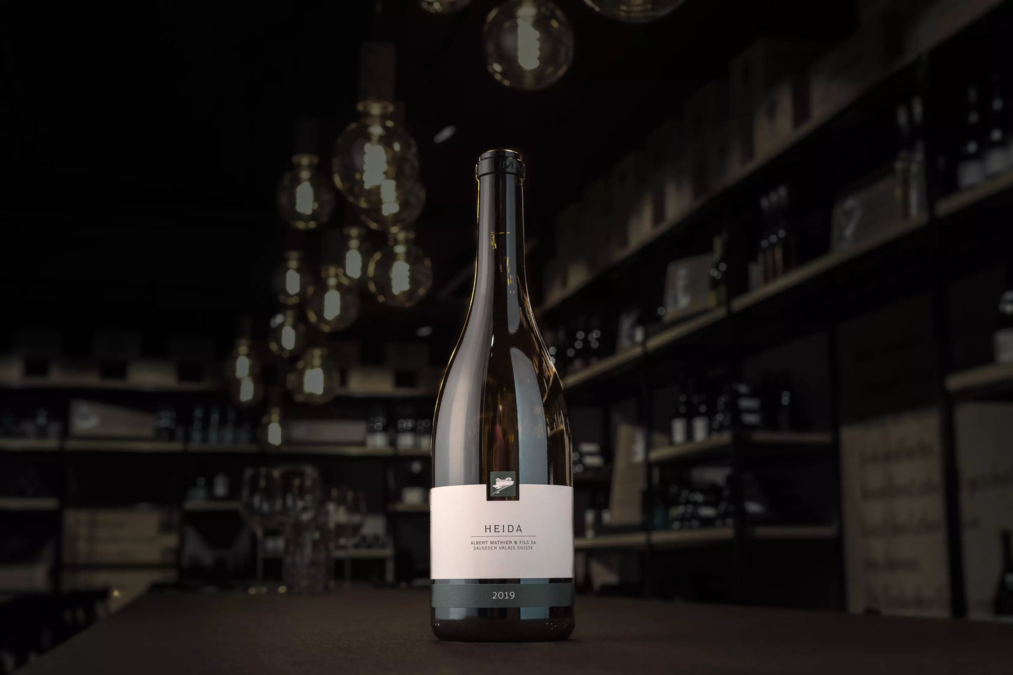 Flasche Heida auf dem Tisch in der dunklen Vinothek Hauser.
