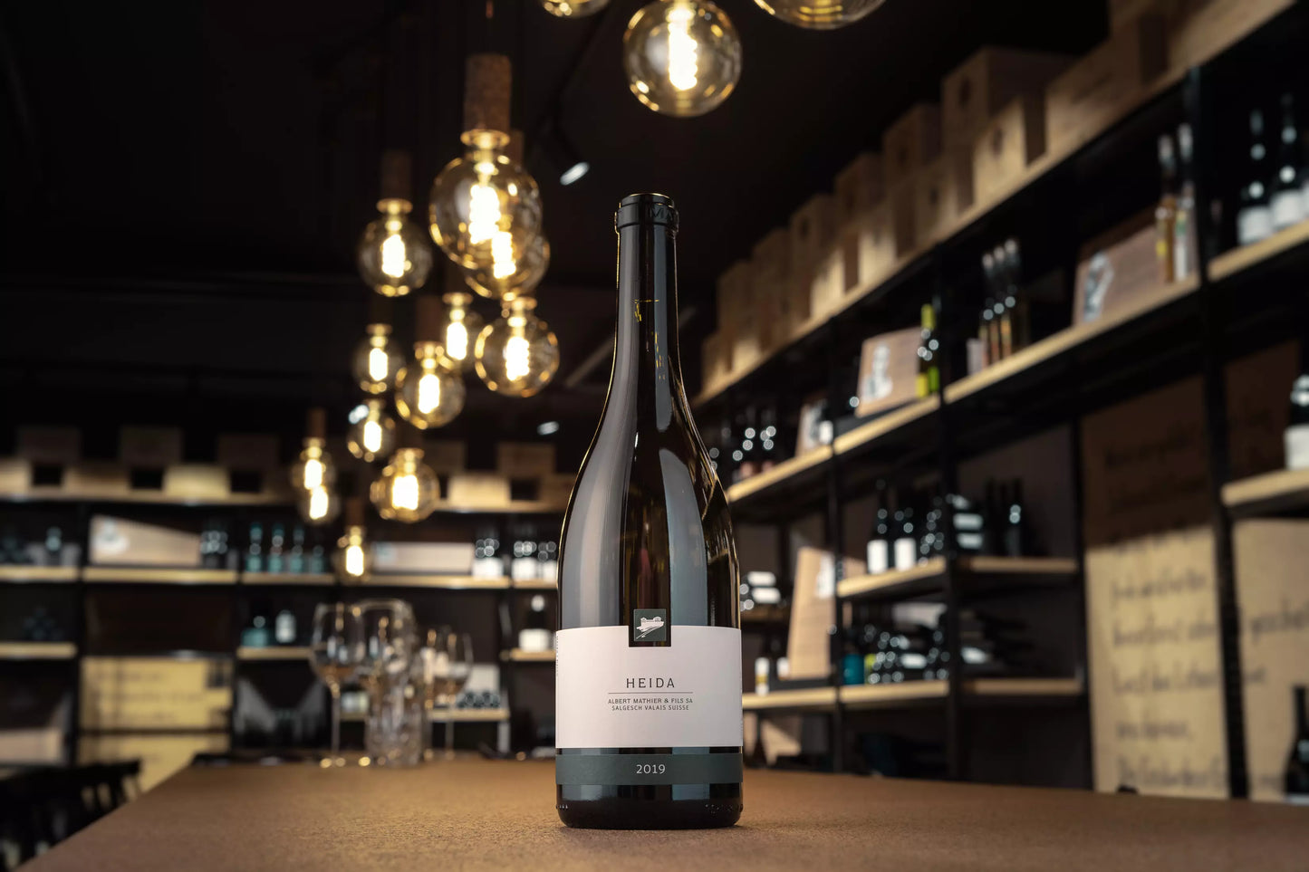 Flasche Heida von Albert Mathier auf dem Tisch im Fokus in der Vinothek Hauser.