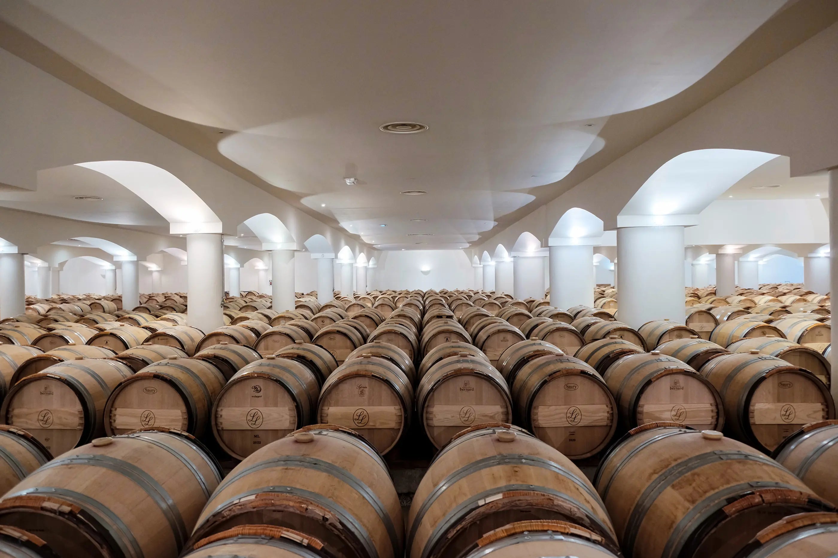 Grosser Barrique-Keller im Château La Lagune mit Säulen und vielen Fässern.