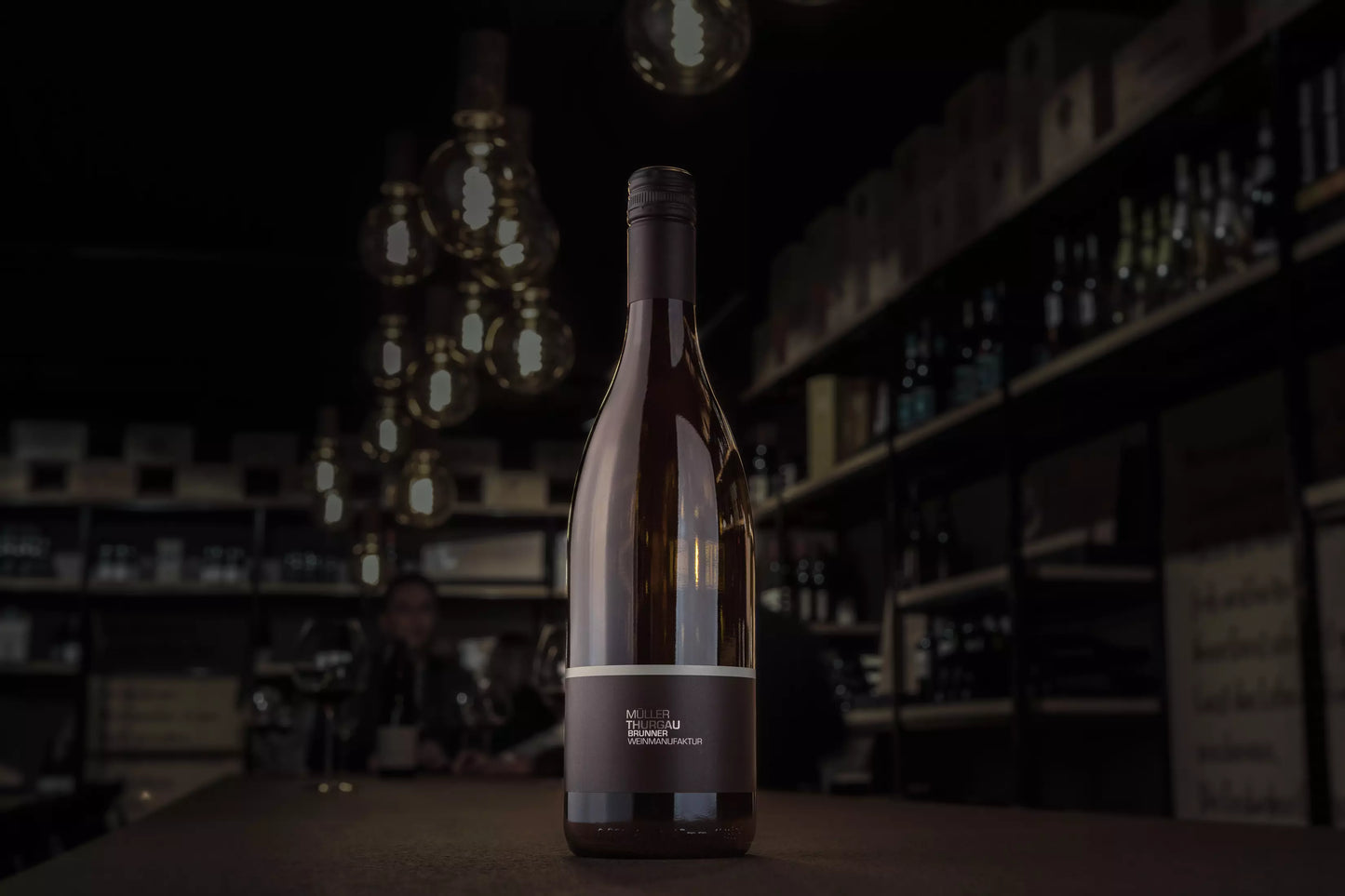 Müller-Thurgau von der Brunner Weinmanufaktur auf dem Tisch in der dunklen Vinothek Hauser.