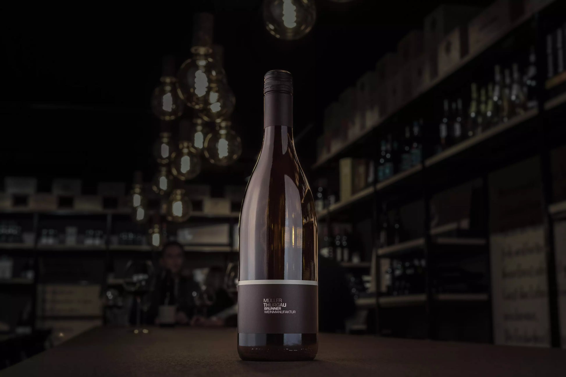 Müller-Thurgau von der Brunner Weinmanufaktur auf dem Tisch in der dunklen Vinothek Hauser.