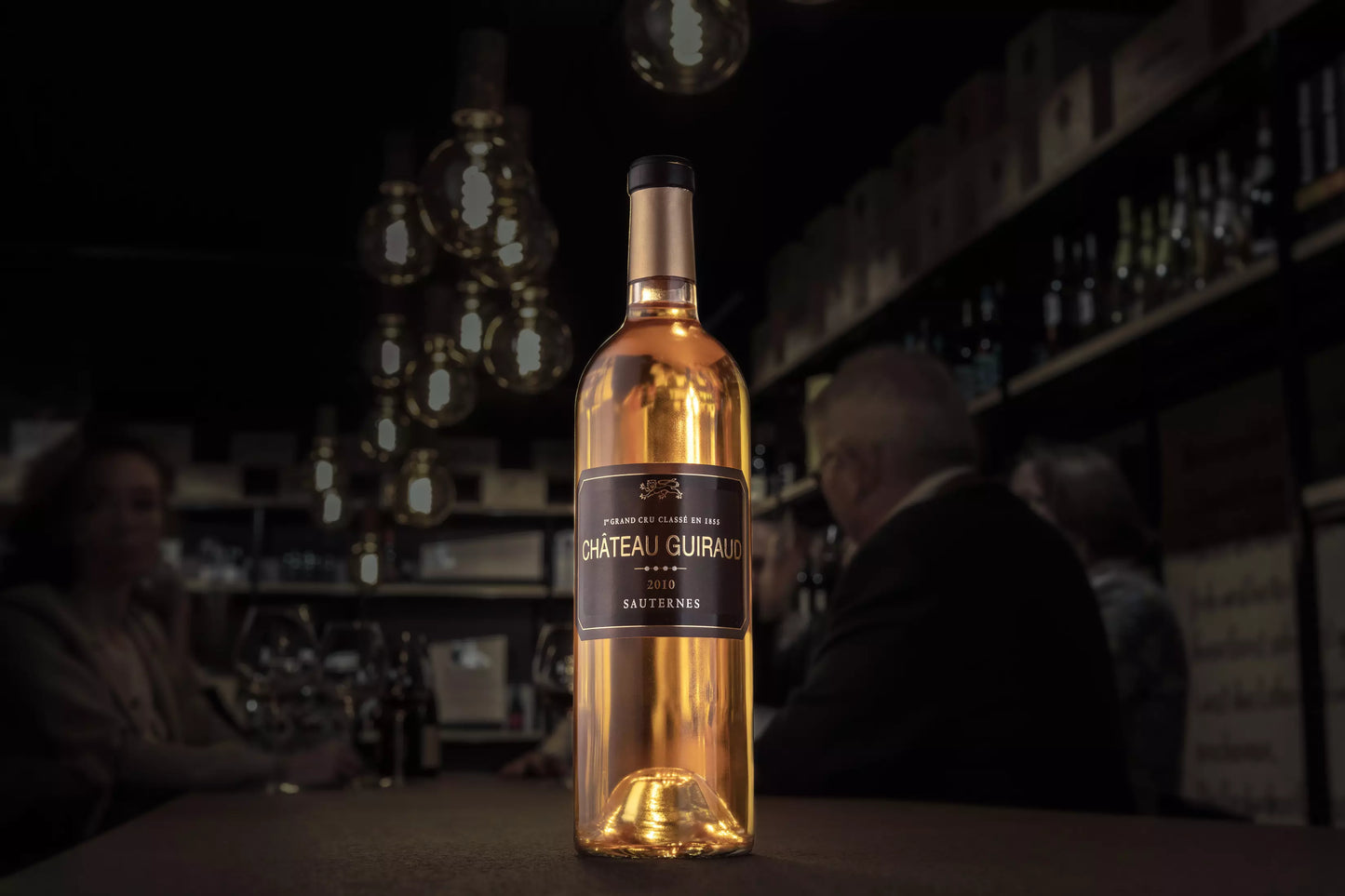 Flasche Château Guiraud 1er Cru Classé auf dem Tisch in der dunklen Vinothek Hauser.