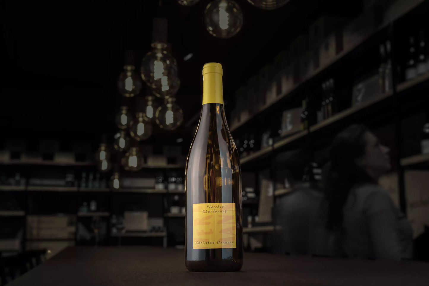 Fläscher Chardonnay von Christian Hermann auf dem Tisch in der dunklen Vinothek Hauser.