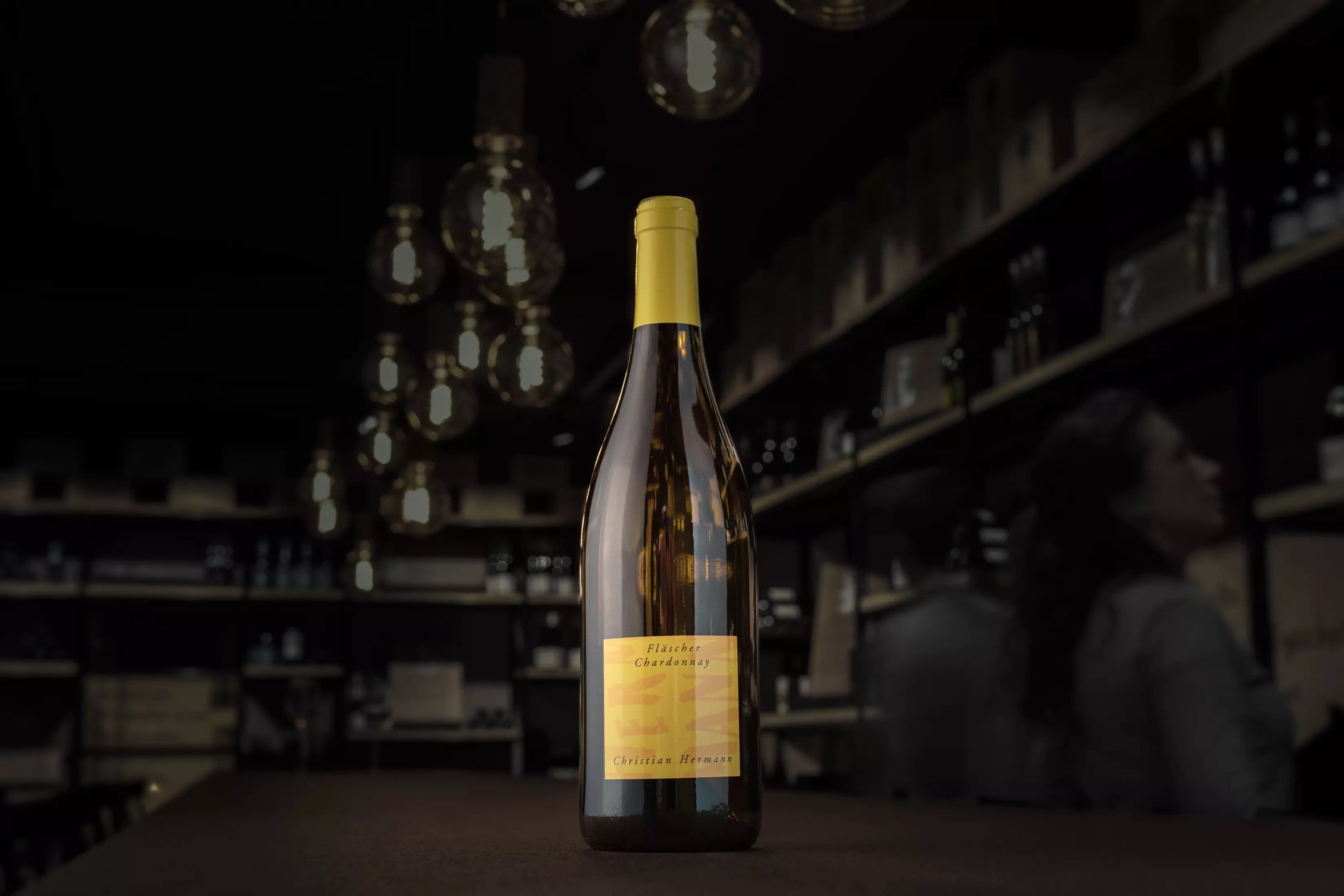 Fläscher Chardonnay von Christian Hermann auf dem Tisch in der dunklen Vinothek Hauser.