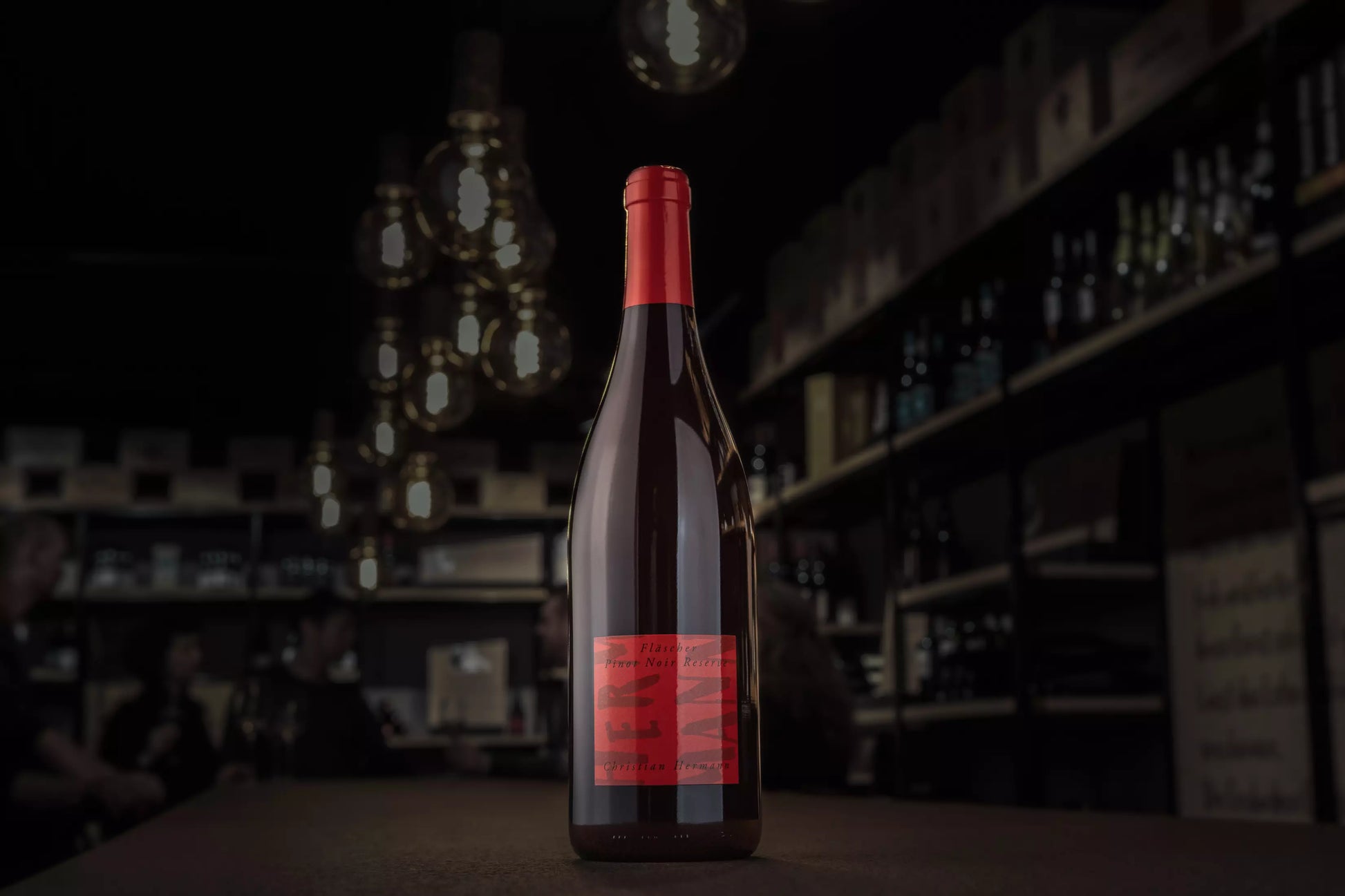 Fläscher Pinot Noir Reserve von Christian Hermann auf dem Tisch in der dunklen Vinothek Hauser.