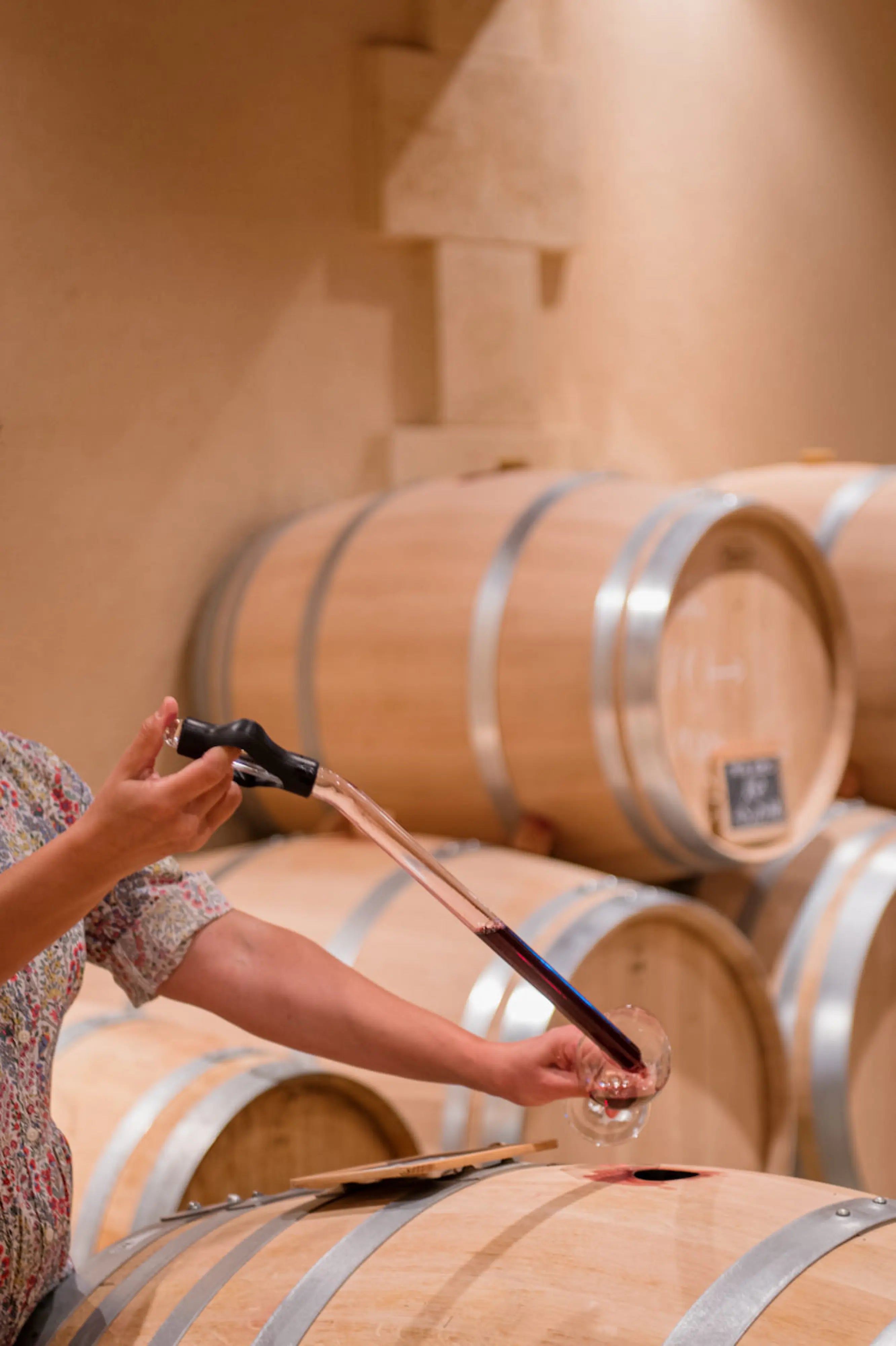 Barrique im Clos de l'Oratoire, von dem eine Fassprobe entnommen und in ein Glas gefüllt wird.