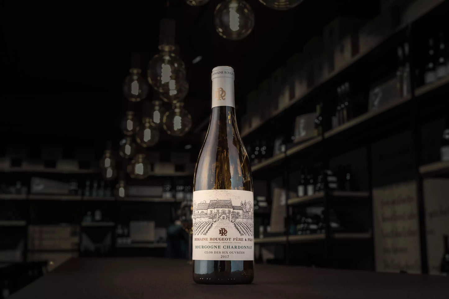Bourgogne Chardonnay Clos des six ouvrées von der Domaine Rougeot auf dem Tisch in der dunklen Vinothek Hauser.