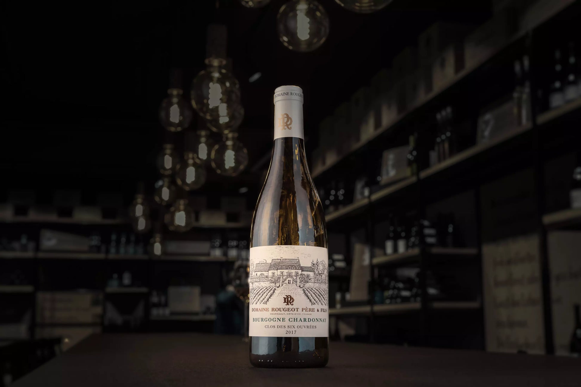 Bourgogne Chardonnay Clos des six ouvrées von der Domaine Rougeot auf dem Tisch in der dunklen Vinothek Hauser.