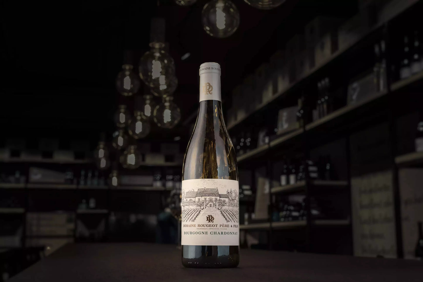 Bourgogne Chardonnay Les Grandes Gouttes von der Domaine Rougeot in der dunklen Vinothek Hauser auf dem Tisch.