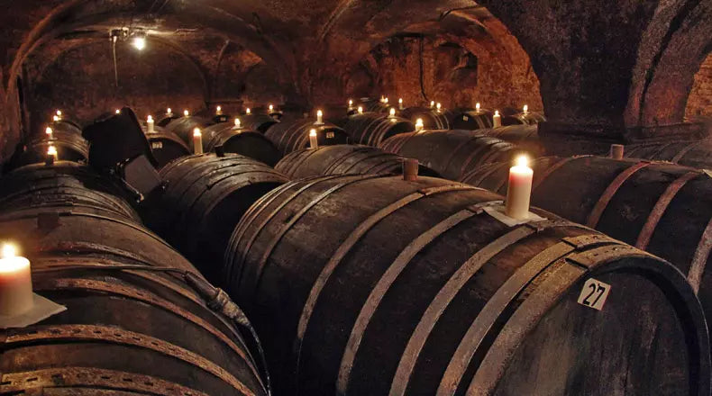 Fasskeller mit Gewölbe und Kerzen auf den Fässern im Weingut von Hövel an der Saar.