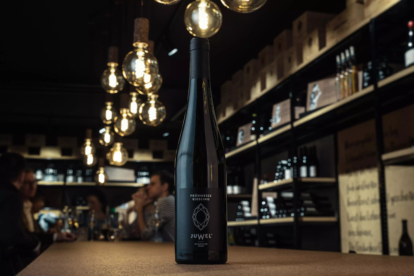 Flasche Frühmesse von Juwel Weine Juliane Eller auf dem Tisch in der Vinothek Hauser