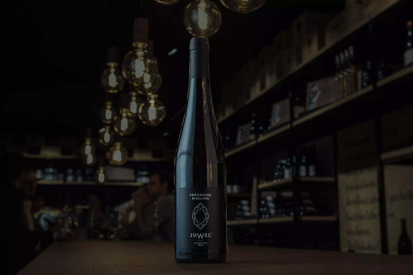 Flasche Frühmesse Riesling von Juwel Weine Juliane Eller auf dem Tisch in der dunklen Vinothek Hauser