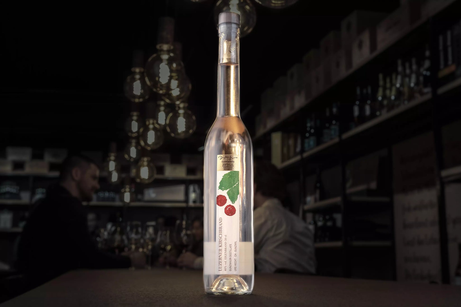 Luzerner Kirsch von Gunzwiler Destillate Urs Hecht auf dem Tisch in der dunklen Vinothek Hauser.