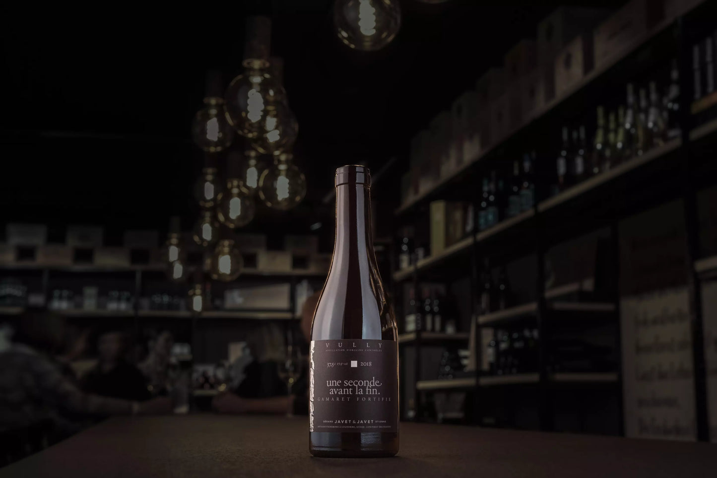 Une séconde avant la fin von Javet & Javet in der dunklen Vinothek Hauser auf dem Tisch.