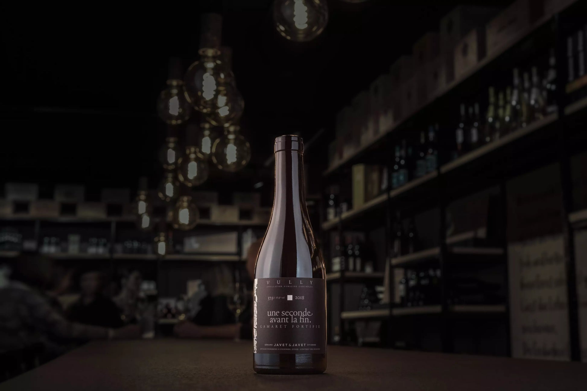 Une séconde avant la fin von Javet & Javet in der dunklen Vinothek Hauser auf dem Tisch.