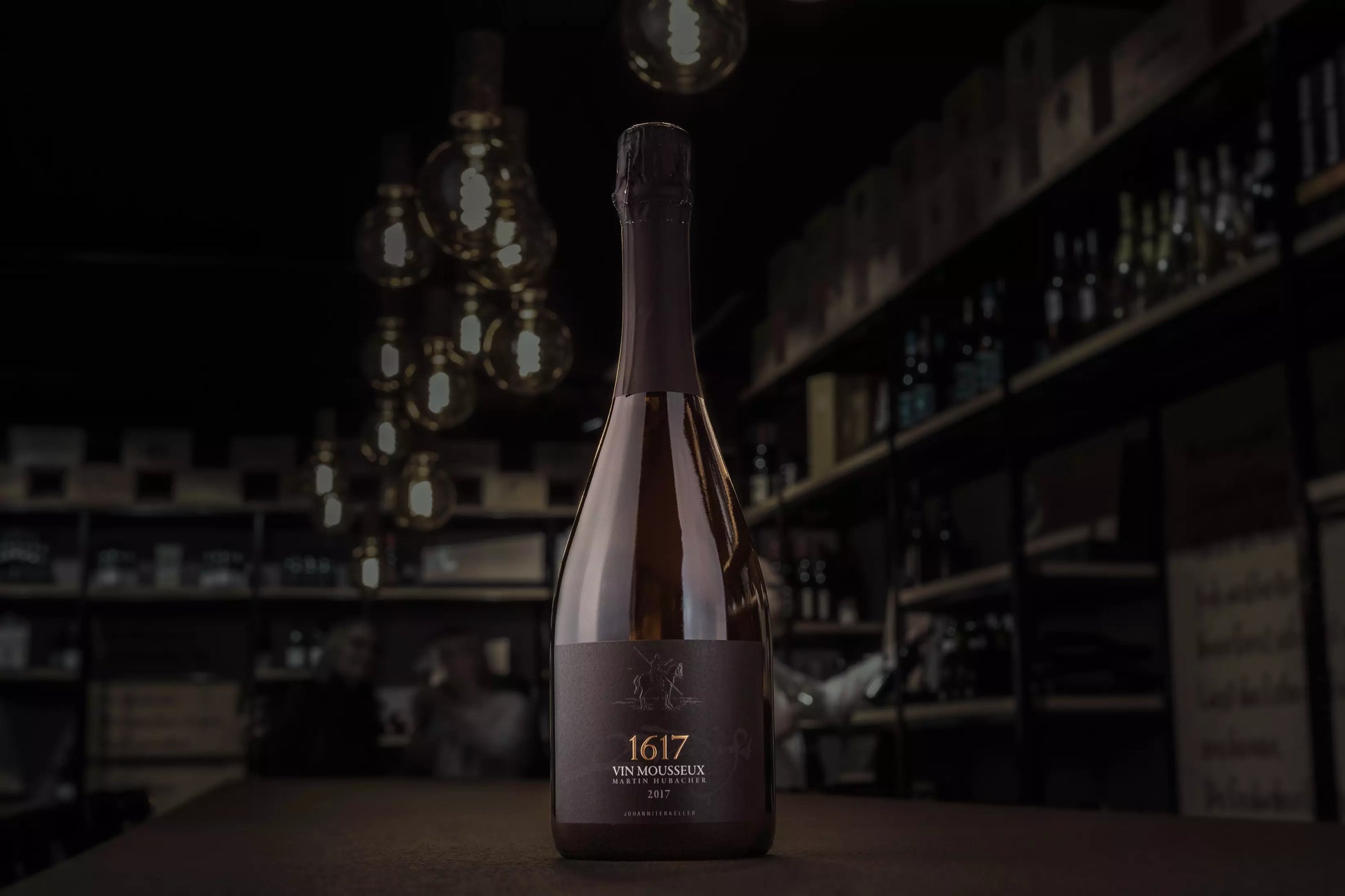 Bendicht 1617 vin mousseux vom Johanniterkeller Martin Hubacher in der dunklen Vinothek Hauser auf dem Tisch.
