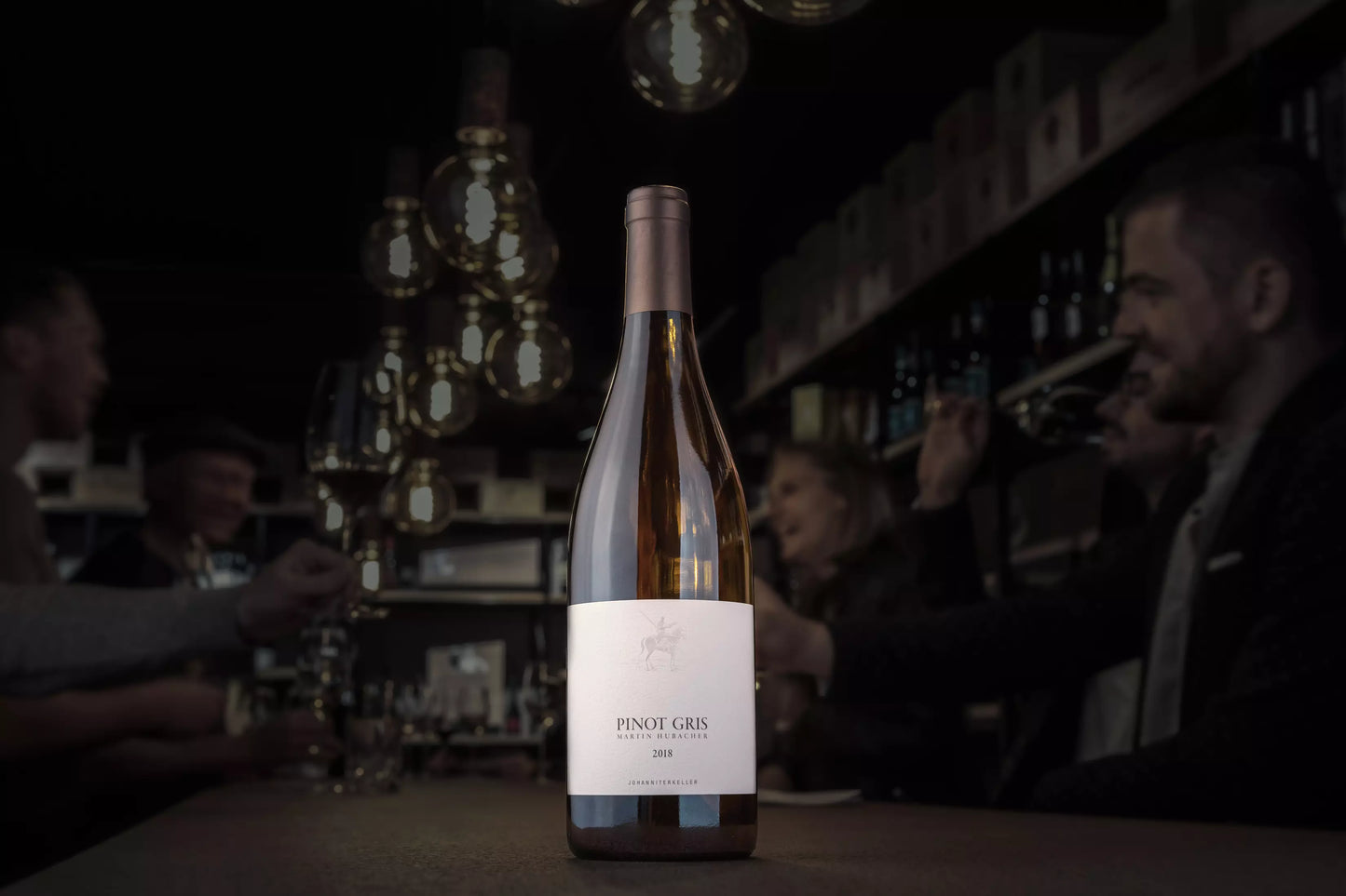 Pinot Gris vom Johanniterkeller Martin Hubacher in der dunklen Vinothek Hauser auf dem Tisch.