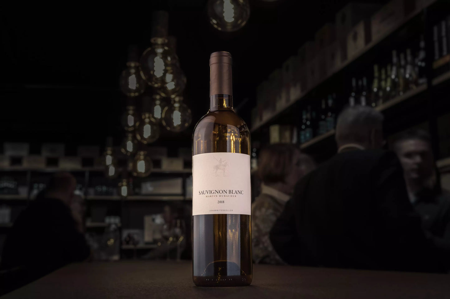Sauvignon Blanc vom Johanniterkeller Martin Hubacher auf dem Tisch in der dunklen Vinothek Hauser.