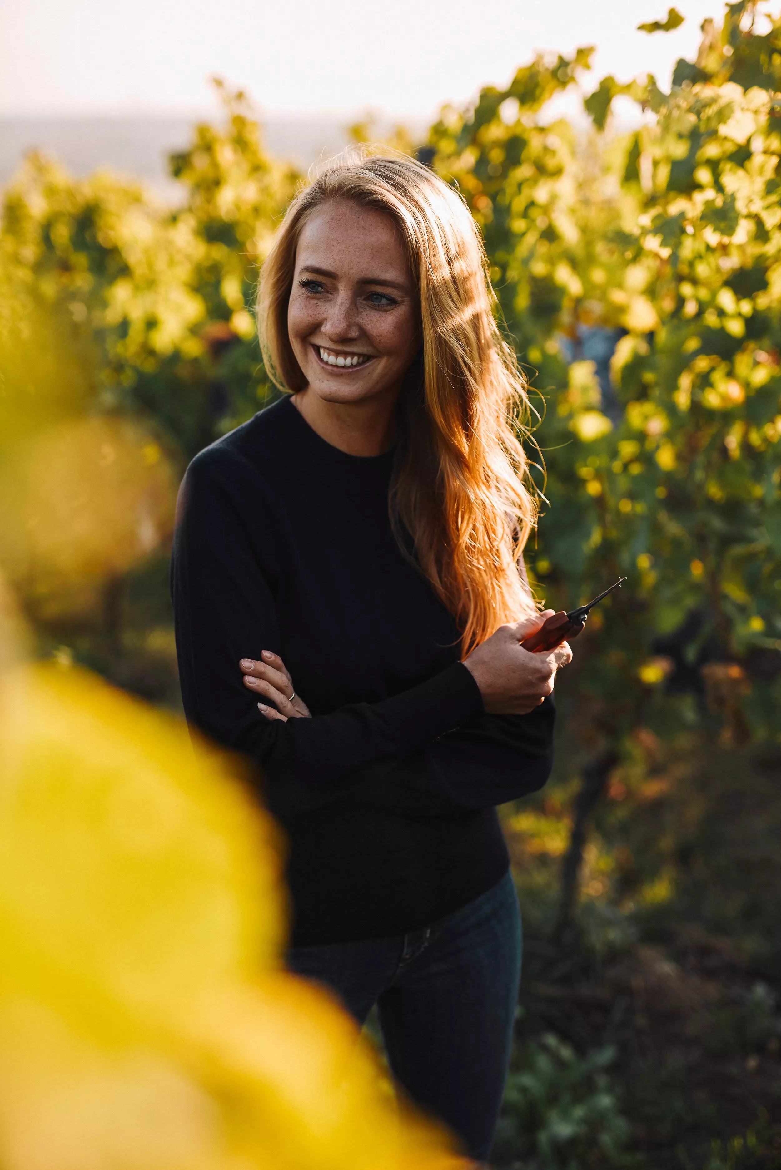 Portrait von Juliane Eller von Juwel Weine in den Rebbergen bei der Ernte.