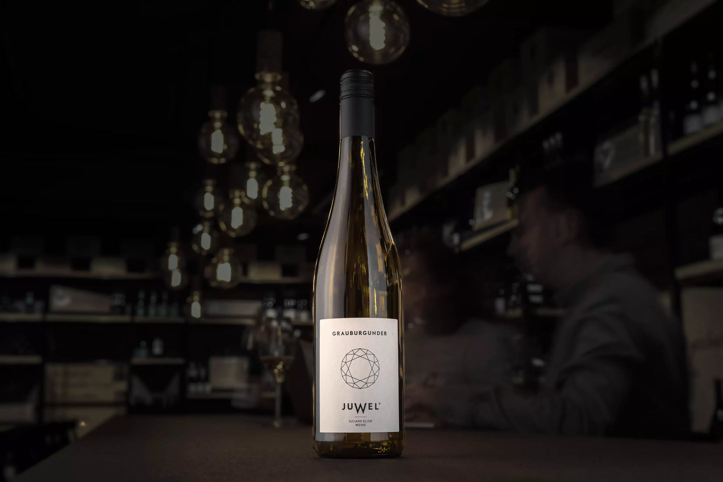 Flasche Juwel Grauburgunder auf dem Tisch in der dunklen Vinothek Hauser