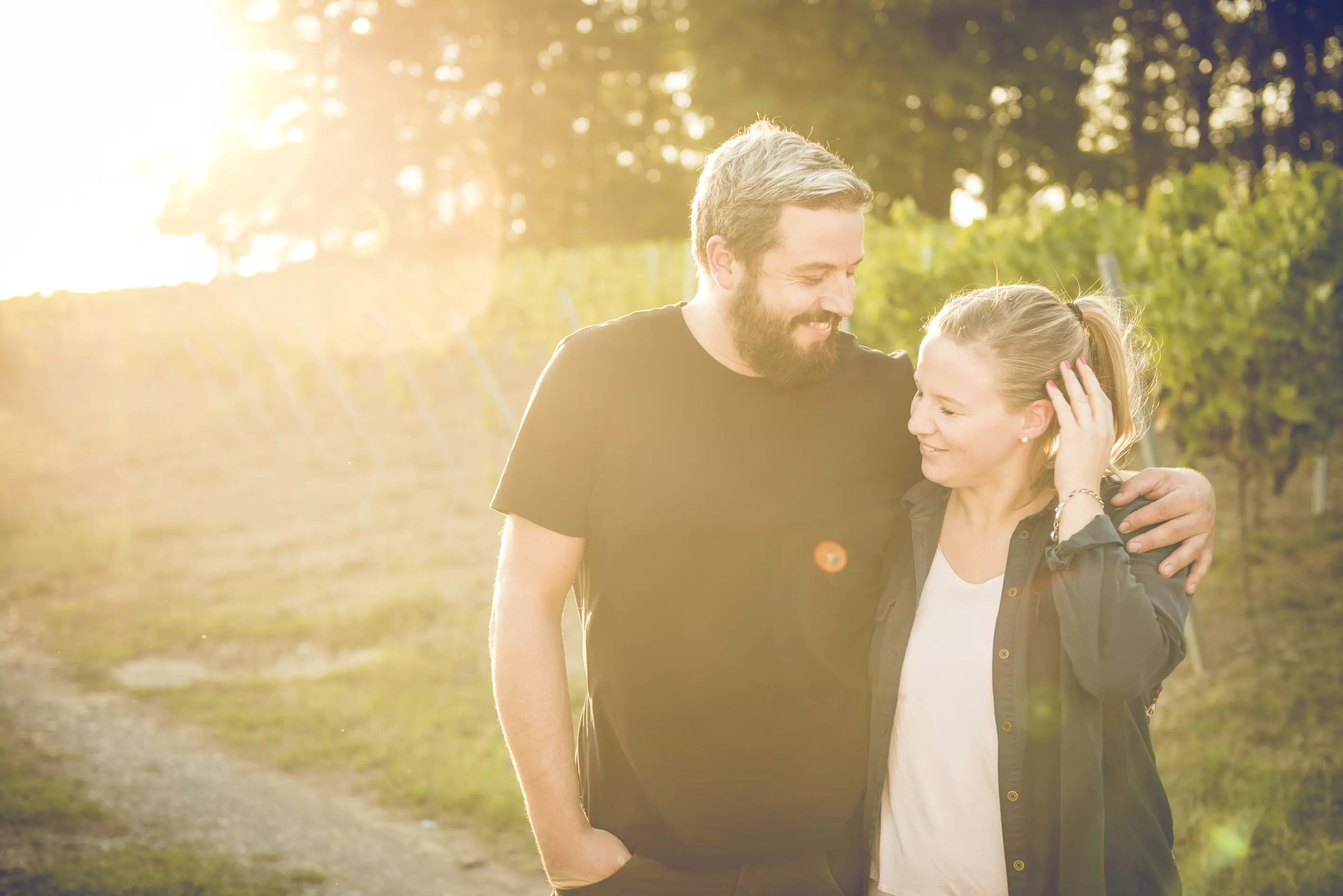 Sina und Frank Kayser in den Rebbergen im Sonnenschein bei Kayser Wein & Sekt.