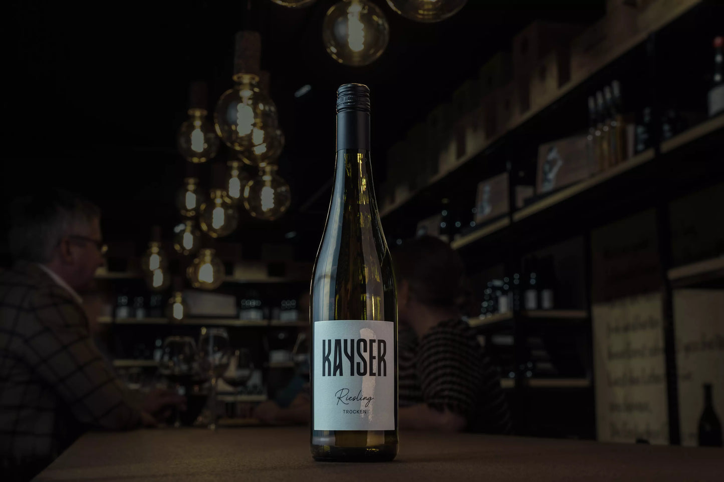 Riesling von Kayser Wein & Sekt auf dem Tisch in der dunklen Vinothek Hauser.