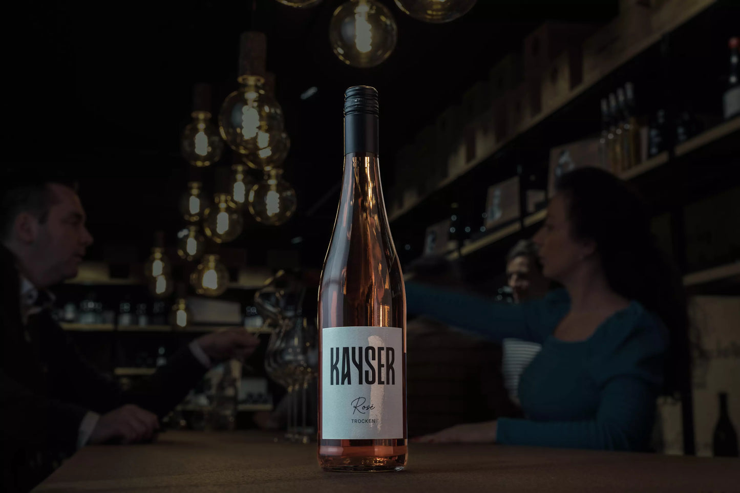 Rosé von Kayser Wein & Sekt auf dem Tisch in der dunklen Vinothek.