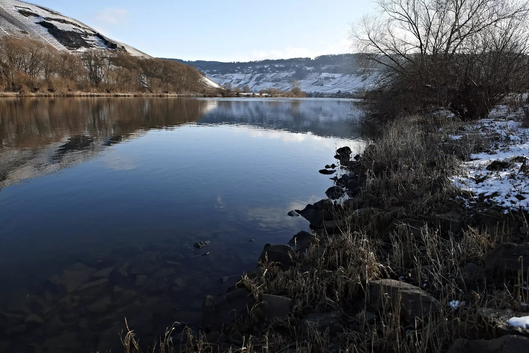Blcik auf die Mosel im Winter mit Weinbau in Steillagen auf er anderen Uferseite.