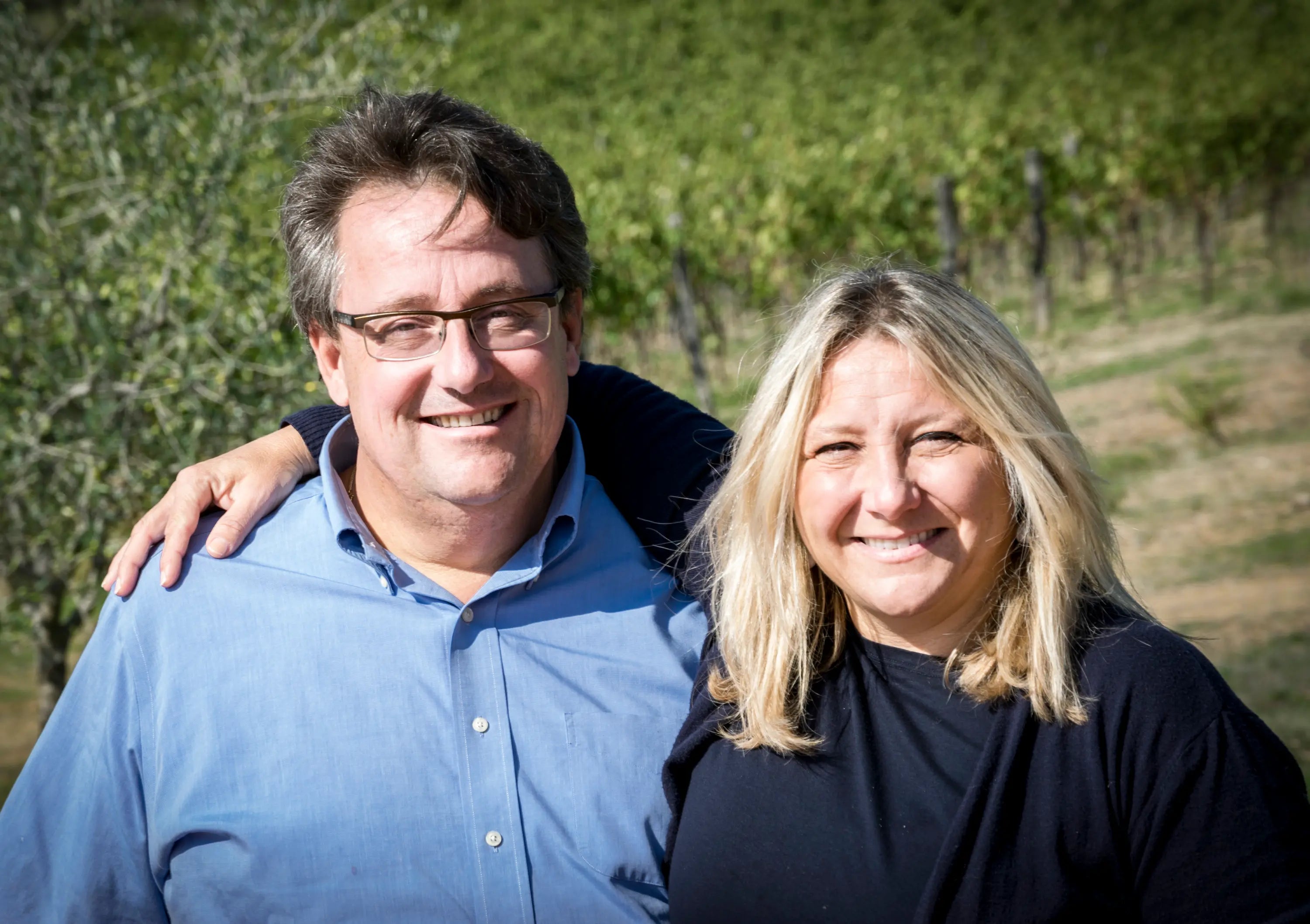 Portrait von Andrea Sommaruga und seiner Frau vom Weingut Panzanellomit Weinbergen im Hintergrund.