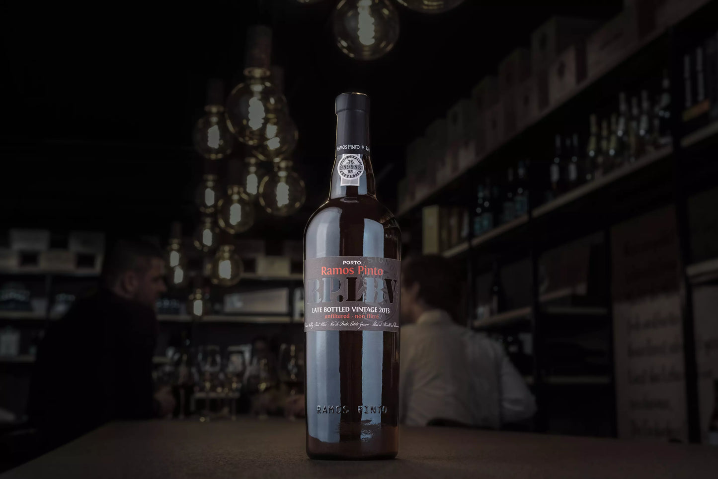 Dunkle Vinothek Hauser mit einer Flasche Late Bottled Vintage LBV von Ramos Pinto auf dem Tisch.