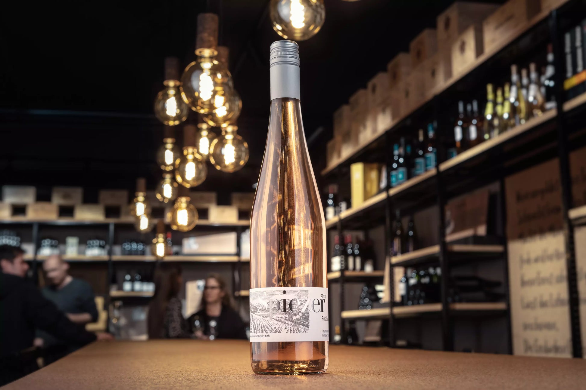 Spiezer Rosé von Alpine Weinkultur Spiez präsentiert auf dem Tisch in der Vinothek Hauser.