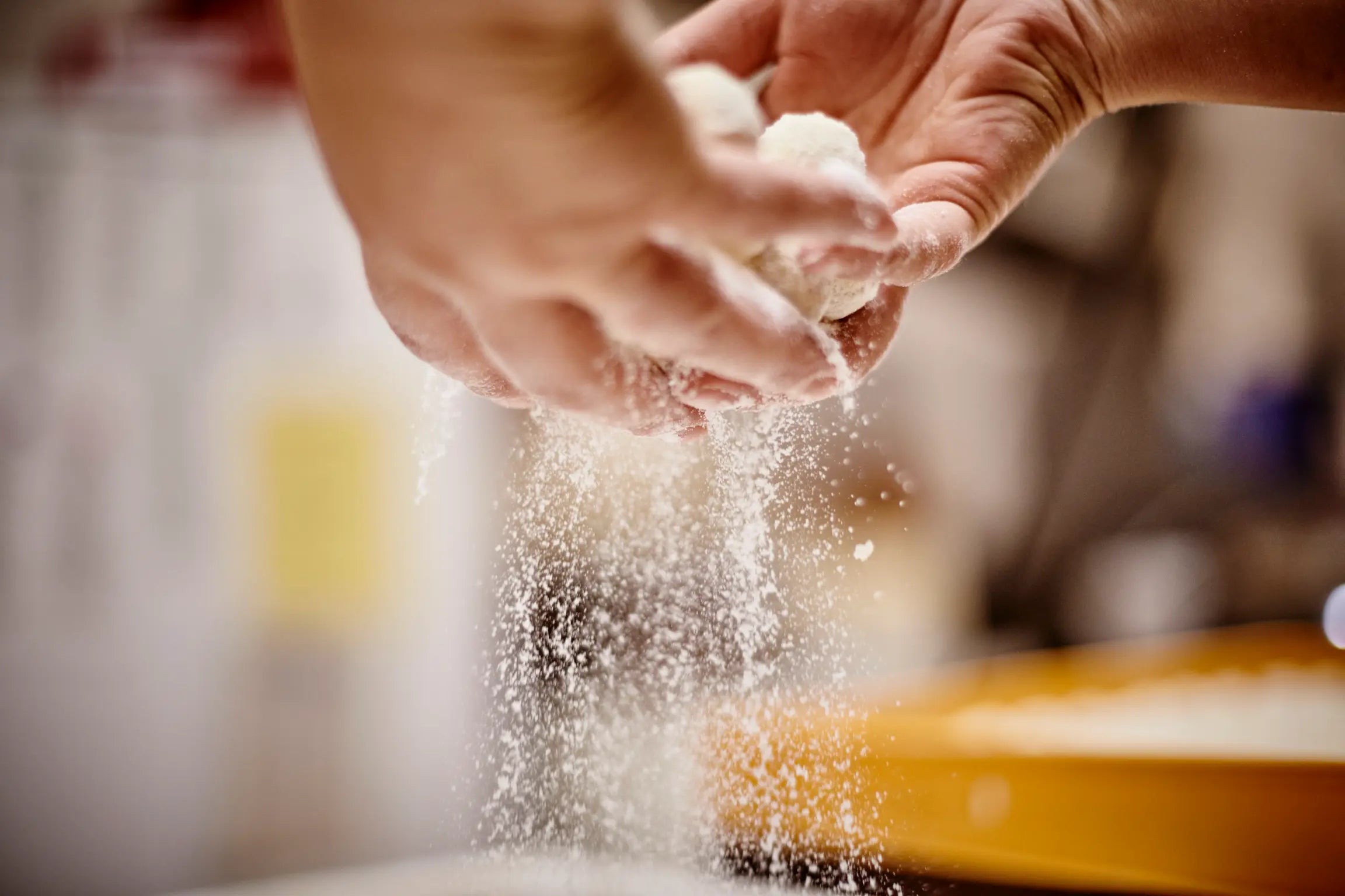 Fertiggestellte Pralinen werden von Hand mit Zucker bestäubt bei Schell Schokoladen.