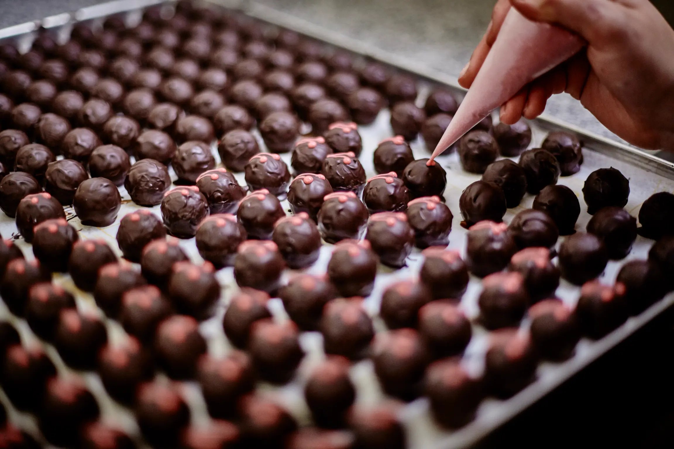 Pralinen werden verziert und von Hand fertiggestellt bei Schell Schokoladen, einer Schokoladen Manufaktur.