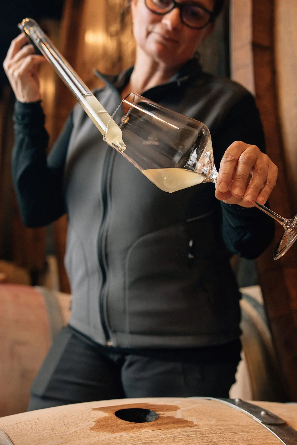 Ursula Irion von Spiezer Alpine Weinkultur bei der Fassprobe im Keller.