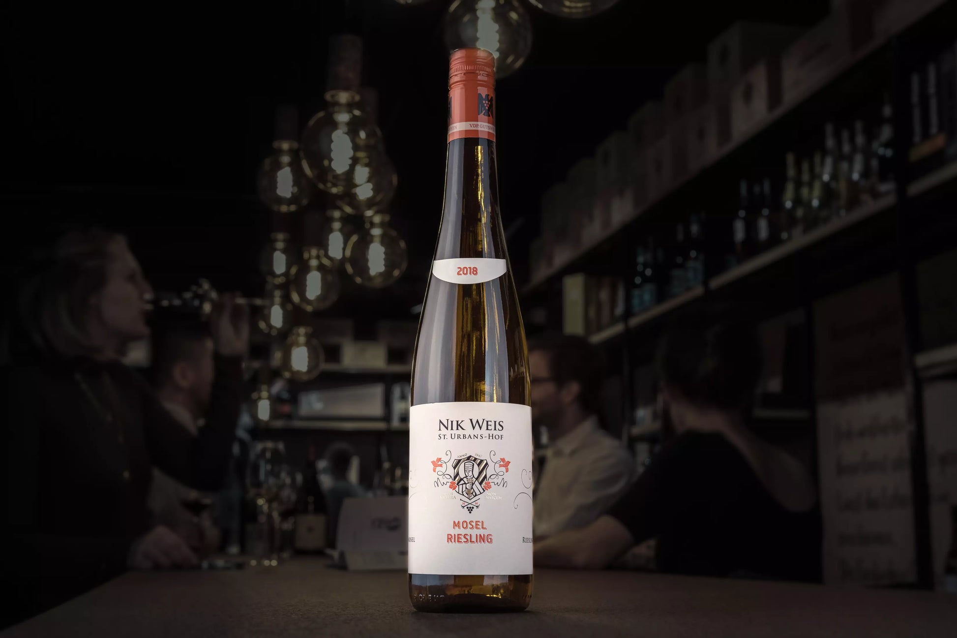Mosel Riesling VDP.Gutswein vom St. Urbanshof Nik Weis in der dunklen Vinothek Hauser auf dem Tisch.