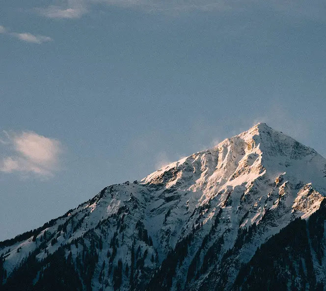 Verschneite Berge am Thunersee im Berner Oberland bei blauem Himmel.