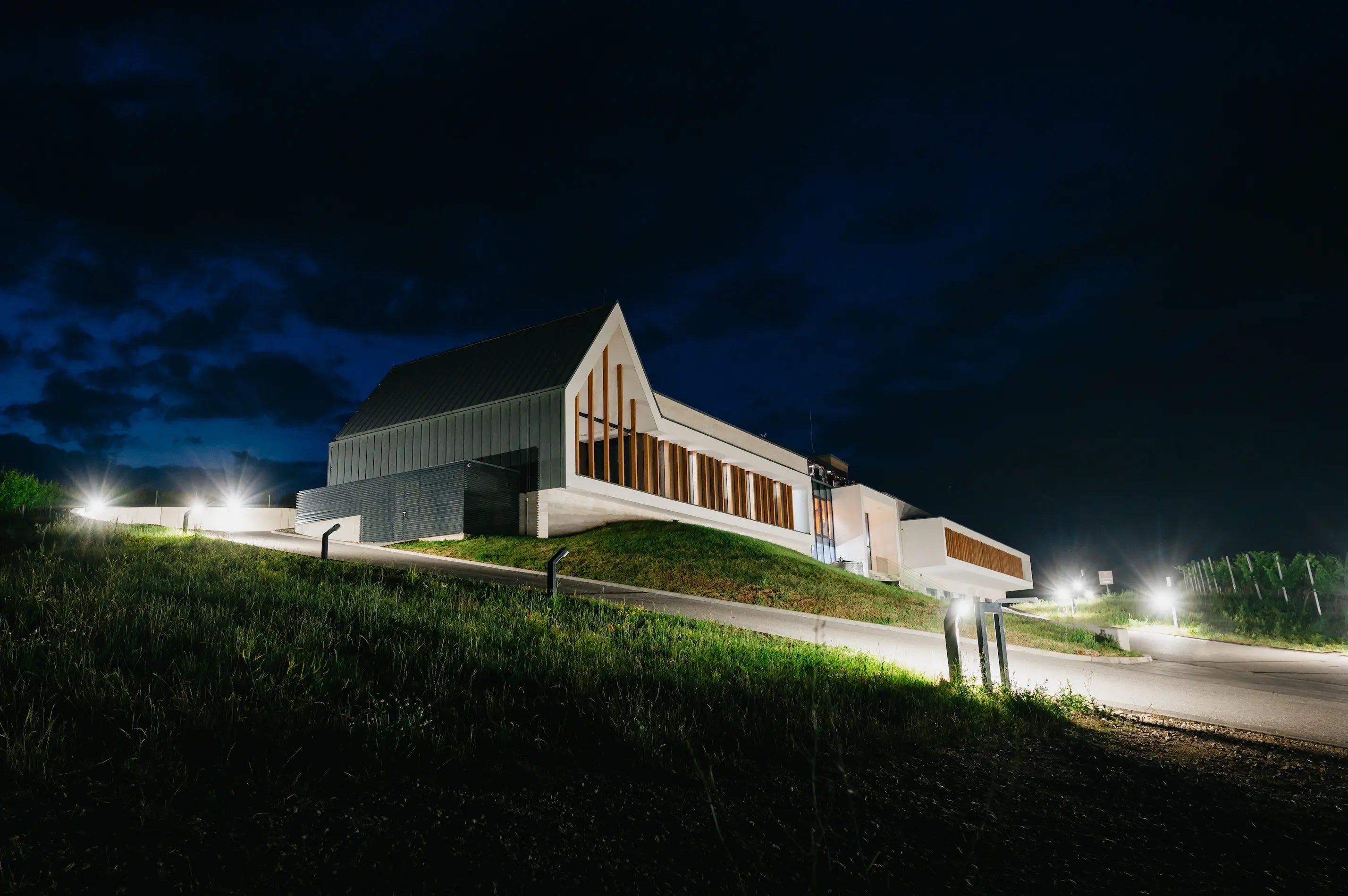 Vilagi Winery von aussen bei Nacht mit Beleuchtung inmitten der Rebberge.