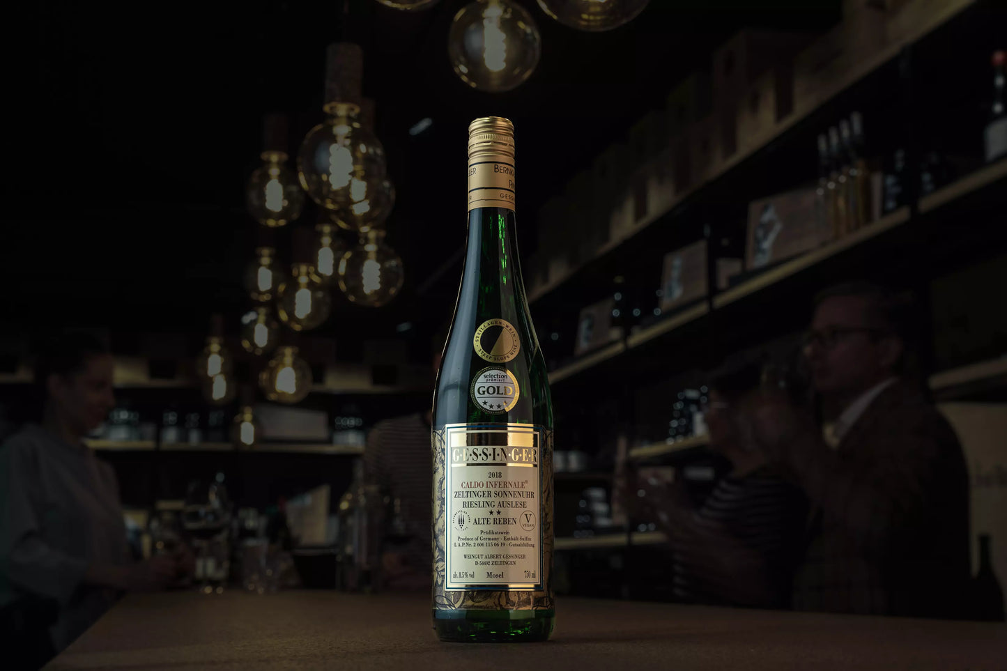 Caldo Infernale Zeltinger Sonnenuhr Riesling Auslese vom Weingut A. Gessinger auf dem Tisch in der dunklen Vinothek Hauser.