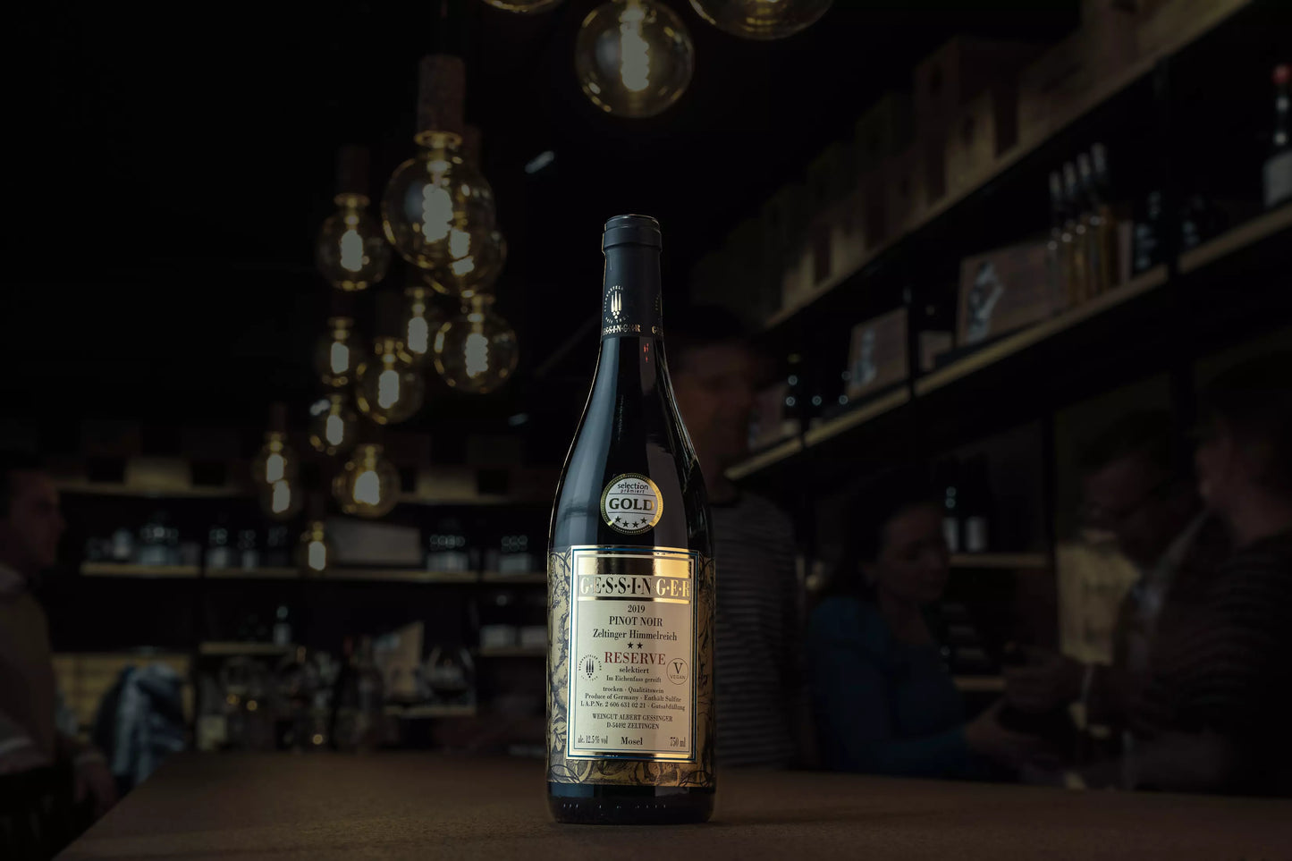 Zeltinger Himmelreich Pinot Noir Reserve vom Weingut A. Gessinger in der dunklen Vinothek Hauser auf dem Tisch.