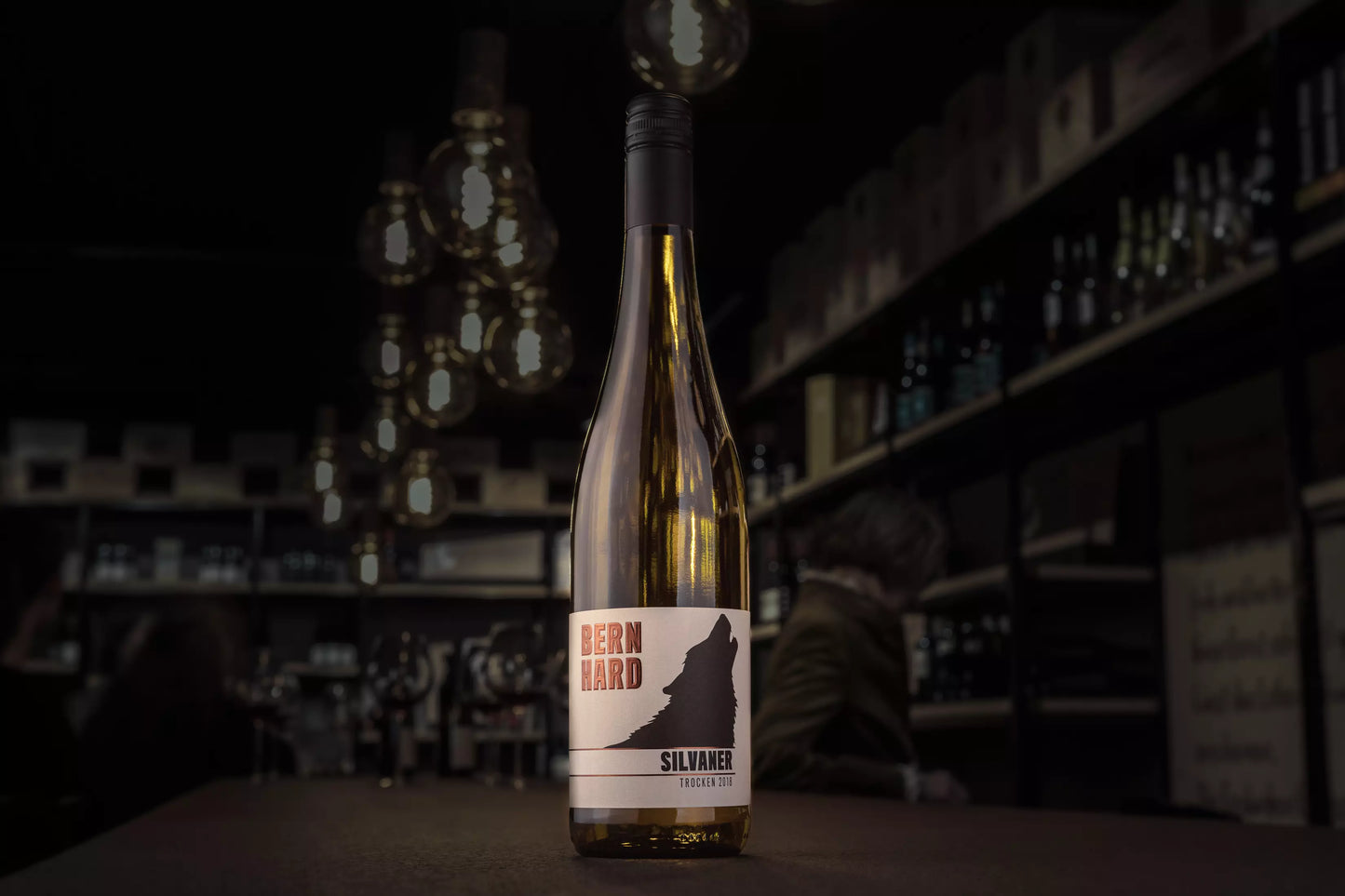 Flasche Silvaner vom Weingut Bernhard in der dunklen Vinothek.