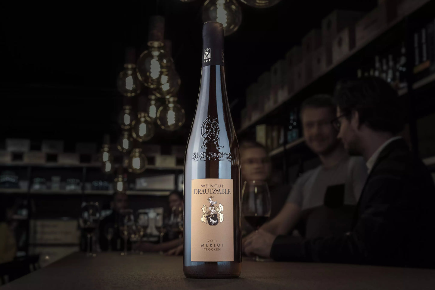Merlot HADES vom Weingut Drautz-Able auf dem Tisch in der dunklen Vinothek Hauser.