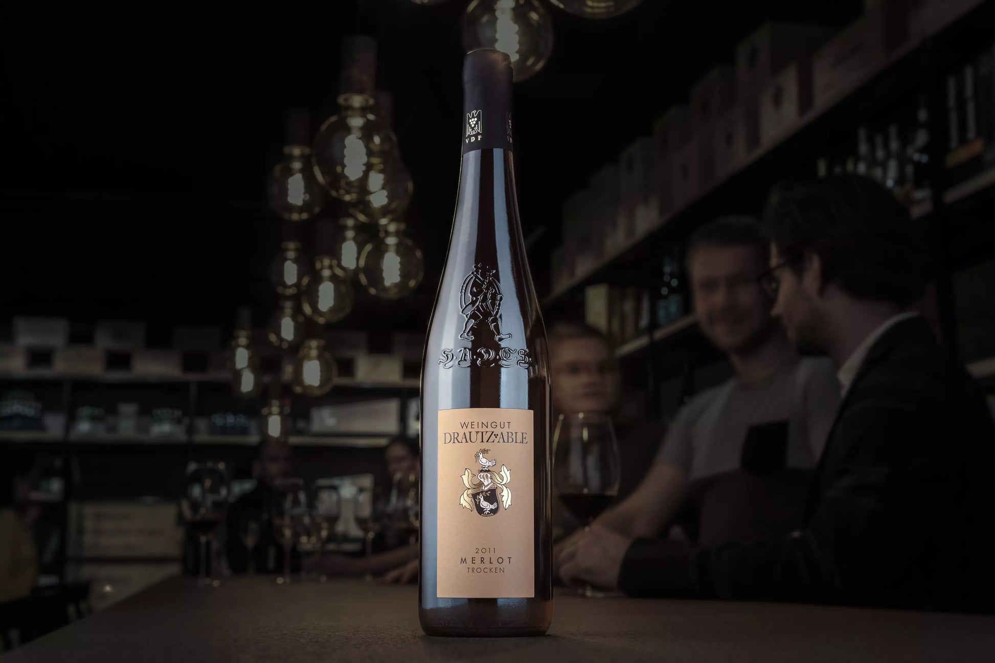 Merlot HADES vom Weingut Drautz-Able auf dem Tisch in der dunklen Vinothek Hauser.