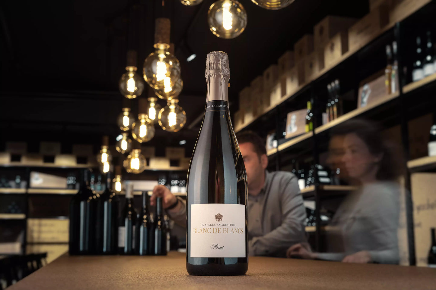 Flasche Blanc de Blancs in der Vinothek Hauser auf dem Tisch.