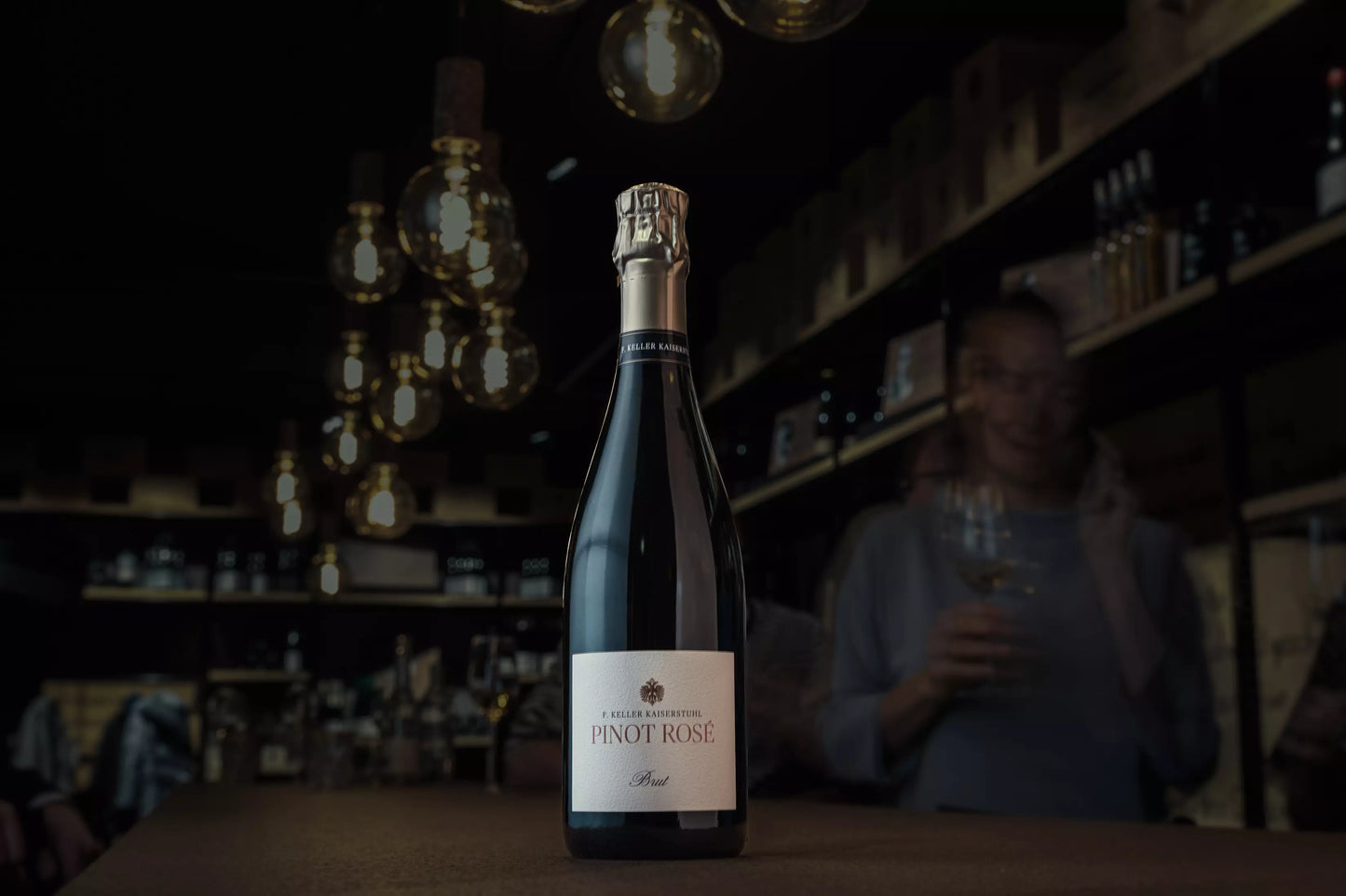 Pinot Rosé Brut vom Weingut Franz Keller Schwarzer Adler auf dem Tisch in der dunklen Vinothek Hauser.