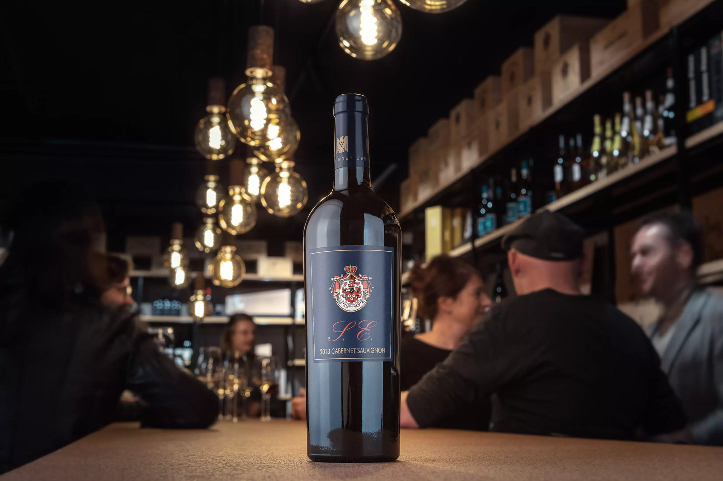 Cabernet Sauvignon S.E. vom Weingut Graf Neipperg in der Vinothek Hauser auf dem Tisch mit Gästen im Hintergrund.