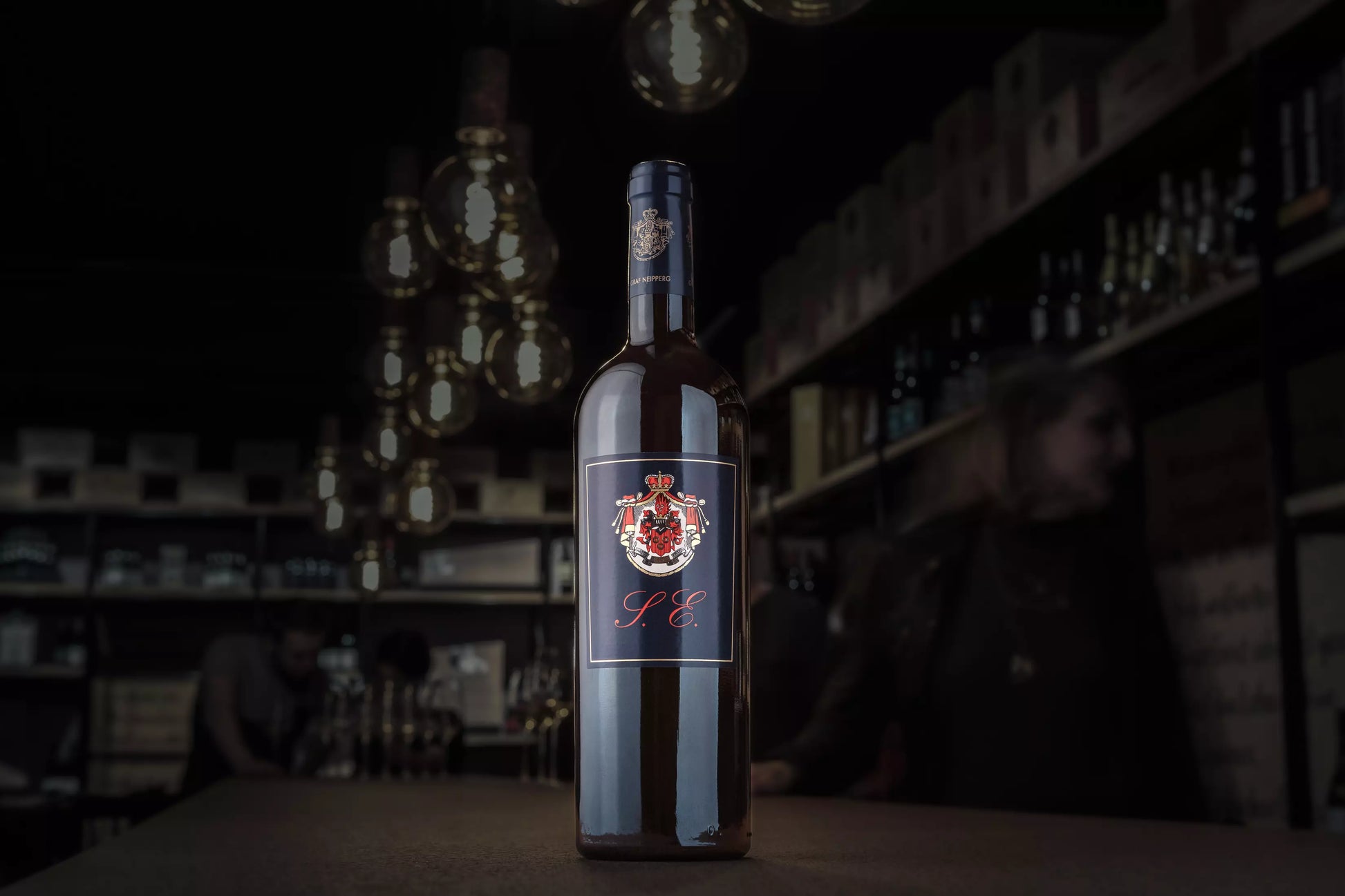 Cuvéee S.E. vom Weingut Graf Neipperg auf dem Tisch in der dunklen Vinothek Hauser.